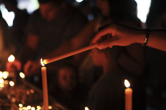 Detail of hand of a woman lighting a candle in the orthodoxe convent of Ostrog, Montenegro