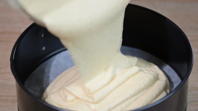 Pouring batter into baking pan greased with butter