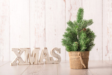 Xmas text and pine tree on wooden