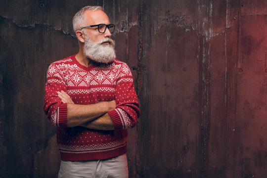 Beautiful Senior Bearded Man In Christmas Sweater Looking Away. Santa Claus Wishes Merry Christmas