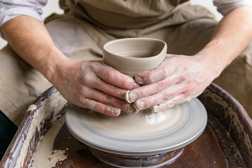 Hands working on pottery wheel