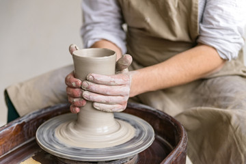 Fototapeta na wymiar Hands working on pottery wheel