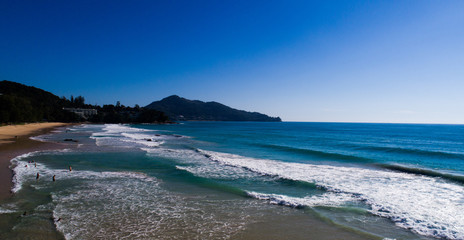 Aerial drone view of people on the beautiful tropical island beach and sea waves during sunny summer day