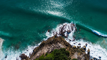 Aerial drone top view of beautiful tropical island and sea waves crashing coastline cliff during...