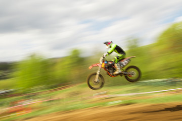 Biker on motocross jump in motion