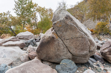 the boulder on the shore of the turquoise river