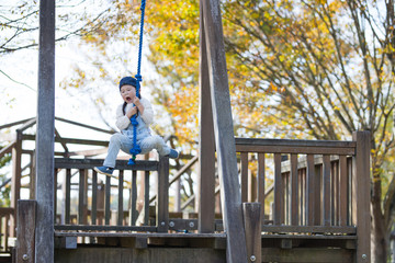 Fototapeta na wymiar Little girl playing in the autumn park