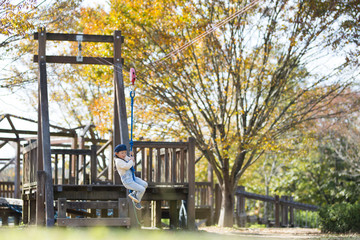 Little girl playing in the autumn park