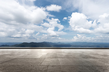 empty marble floor with green hill in cloud sky