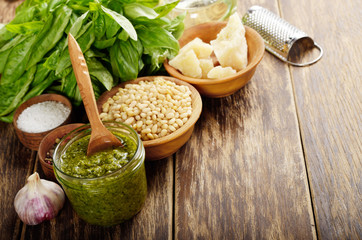 Pesto sauce ingredients and utensils on wood table