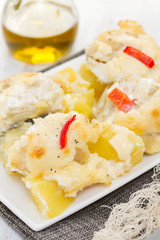 cod fish with potato and sauce on white dish