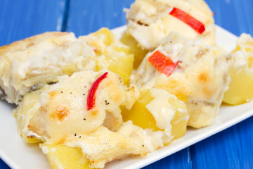 cod fish with potato and sauce on white dish