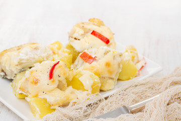 cod fish with potato and sauce on white dish