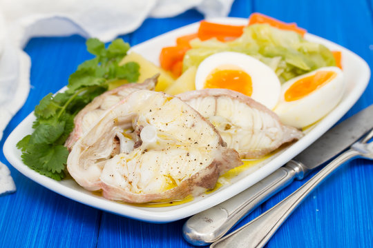 boiled fish with boiled vegetables on white plate