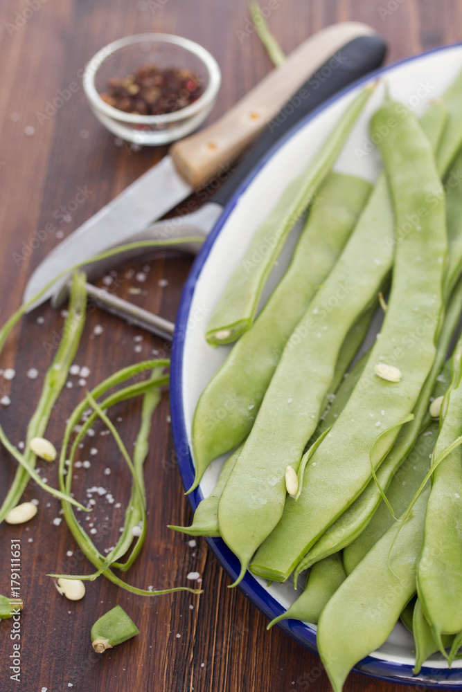 Poster  fresh green beans on dish on wooden background