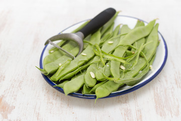  fresh green beans on dish on wooden background