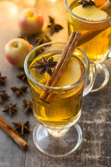 Close up mulled cider in glass on wooden table
