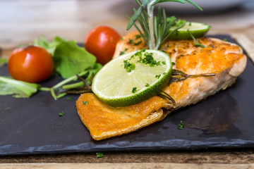 grilled salmon and lemon - french cuisine dish with tomato and salmon