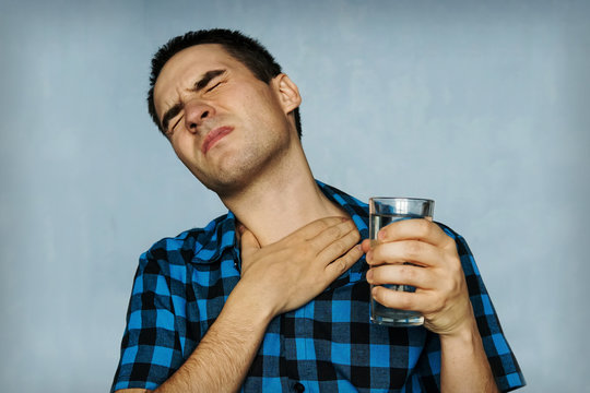 Portrait man coughing, pressing on chest with painful expression.