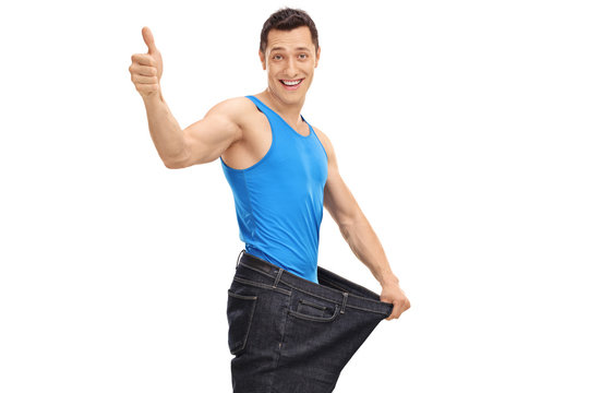 Young guy in oversized jeans giving a thumb up