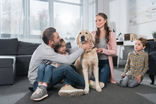 Family Sitting On Floor With Dog