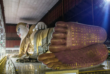 big buddha Kyauk Htat Gyi  reclining buddha statue in Myanmar (Burma) at night  selective focus detail of foot © Soonthorn