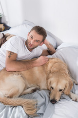 man lying in bed with dog