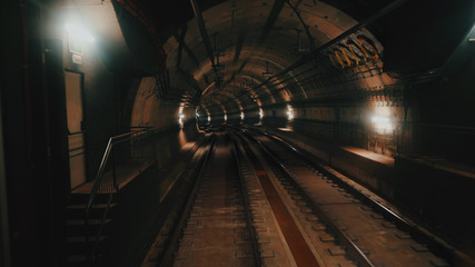 View of subway tunnel as seen from reverse of moving backward train. Fast underground train riding in tunnel of modern city. Underground train in Barcelona following its route