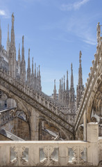 White marble statues on the roof of famous Cathedral Duomo di Milano on piazza in Milan, Italy