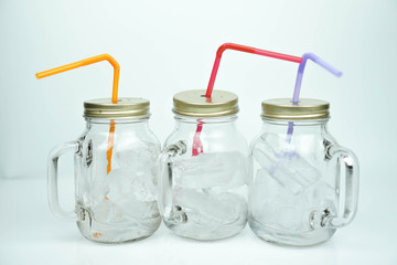 Ice in emply mug or glass with lid on white background, straw