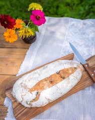 Still life with organic bread. Tasty fresh baked bread photographed on table in garden