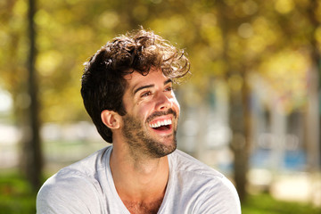 Close up handsome man with beard laughing outside