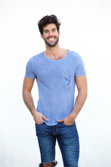 Fototapeta premium Smiling handsome man standing isolated on white wall