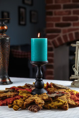 beautiful burning candle on the wooden carved candle holder stands holiday table