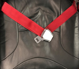 Red airplane safety belt on black seat