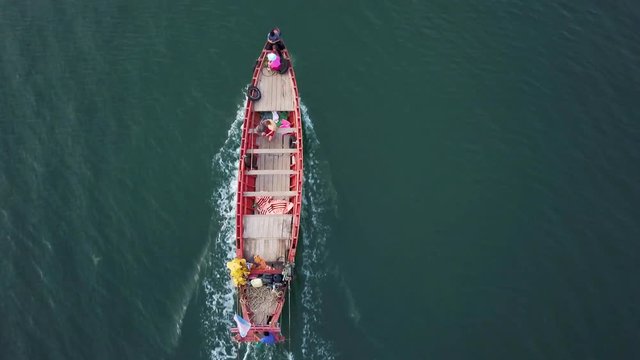 Looking straight down, an aerial camera follows a wooden tourist ferry boat as it travels across the Gulf of Siam to the mainland, Kep, Cambodia.