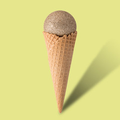 Ice cream cone with christmas ball on bright yellow background. Minimal style.  Holiday concept.