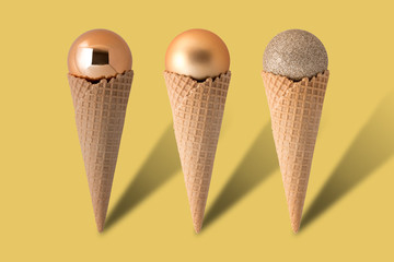 Ice cream cones with christmas balls on bright yellow background. Minimal style.  Holiday concept.