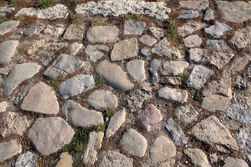 Top view on ancient road paved with cobblestones.