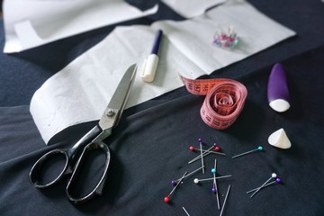 Sewing accessories , fabric , scissors, chalk, neeedles and measuring tape. Top view. Atelier.