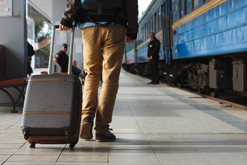 Young man carrying his luggage in the train station,traveling concept.,copy space. Customs near the train entrance