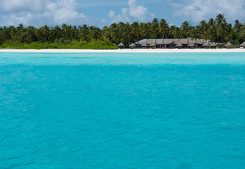 Tropical beach Maldives with palm trees and blue lagoon. Tropical island with coconut palm trees on white sandy beach. Maldives, Indian Ocean. Dreamlike beach luxury Islands. Untouched tropical beach.