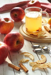 Tazza di infuso su tagliere e mele rosse