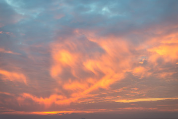 The sunrise dramatically illuminates the clouds with color.