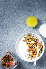 Maple cranberry almond granola yogurt bowl on dark concrete background. Top view, space for text.
