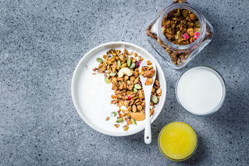 Peanut butter honey granola yogurt breakfast bowl on dark concrete background. Top view, space for text. 