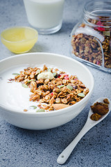 Chocolate cinnamon coconut granola yogurt  breakfast bowl on dark concrete background. Selective focus, copy space.