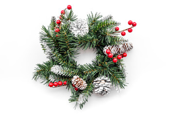 Christmas wreath woven of spruce branches with red berries on white background top view