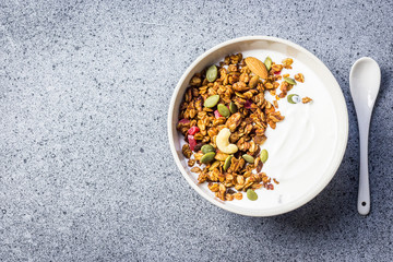 Granola yogurt bowl on dark concrete background. Top view, space for text. Selective focus, copy space.