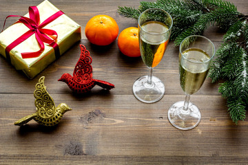 Glasses of champagne in eve of New Year 2018 near spruce branch and gift on wooden background copyspace
